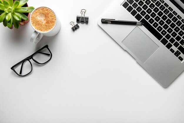 Flat lay desk with laptop and glasses