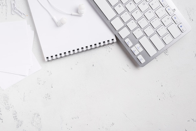 Flat lay of desk with notepad and keyboard