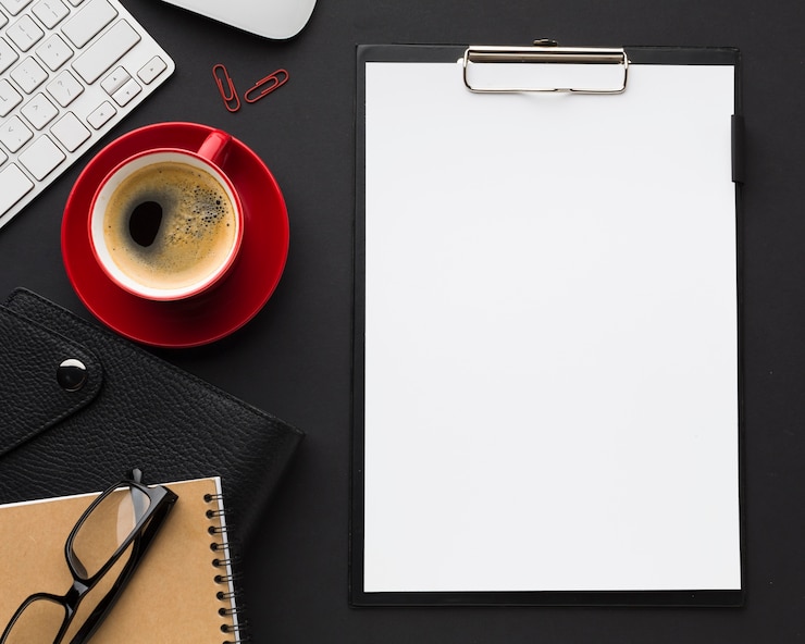 Free Photo flat lay of desk with paper and coffee cup