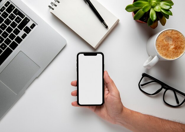 Flat lay desk with phone in hand