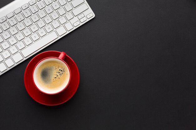 Flat lay of desktop with coffee cup and keyboard