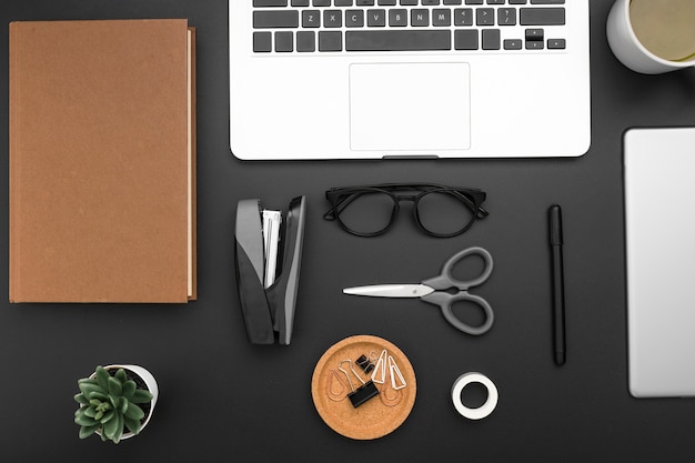 Flat lay of desktop with laptop and scissors