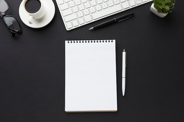 Flat lay of desktop with notebooks and keyboard