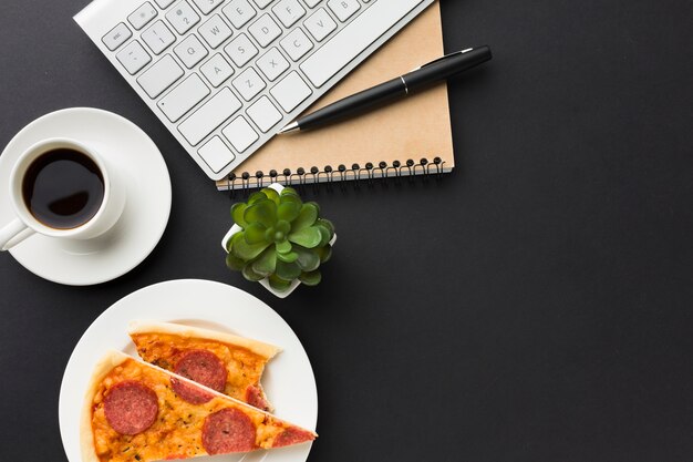 Flat lay of desktop with pizza and coffee cup