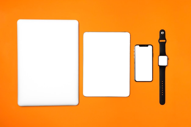 Flat lay devices on orange background
