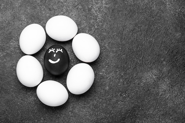 Flat lay of different colored eggs with faces for black lives matter movement and copy space