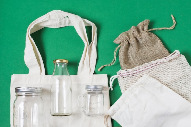 Flat lay different zero waste products on green background