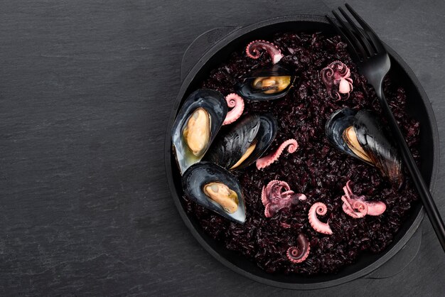 flat lay of dish with black pasta and mussels