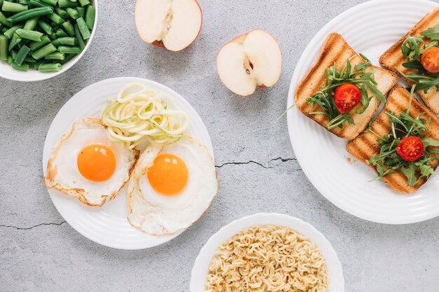 Flat lay of dishes with fried eggs and apples