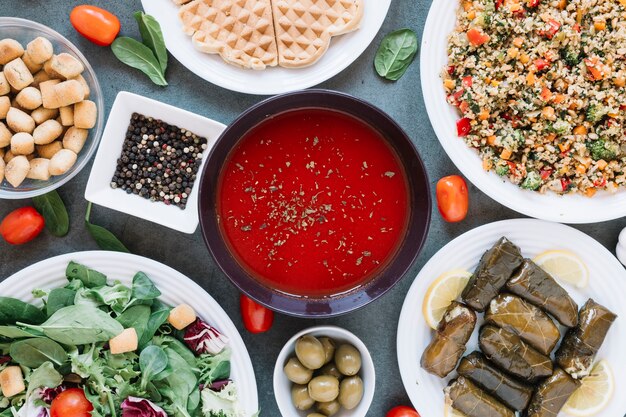 Flat lay of dishes with tomato soup and pepper