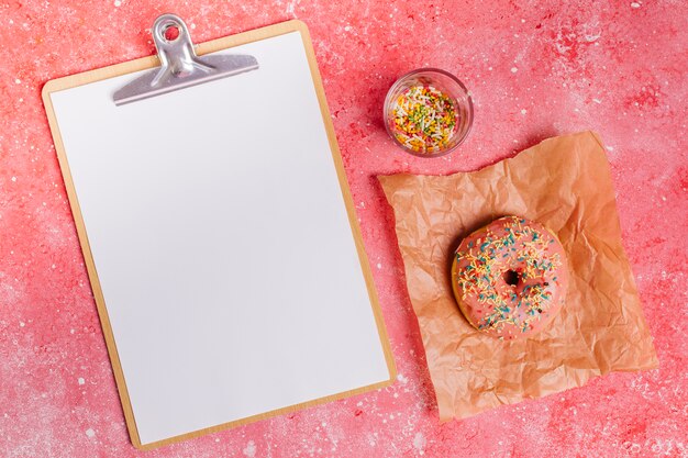 Flat lay donut composition with clipboard