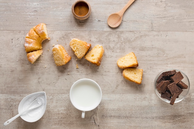 Flat lay of donut pieces with milk and chocolate