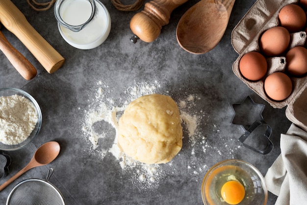 Flat lay dough on counter with flour and eggs