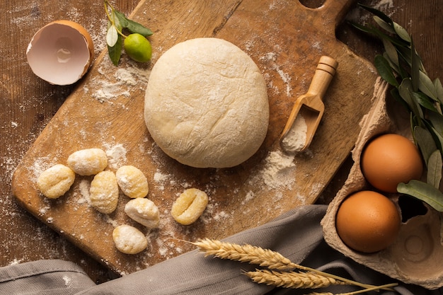 Flat lay dough and potato gnocchi on cutting board