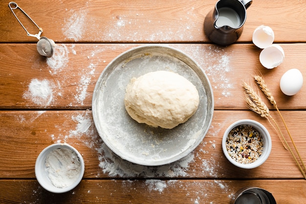 Flat lay of dough on tray on wooden table