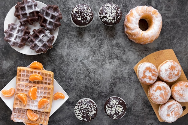 Flat lay of doughnuts and waffles on plates