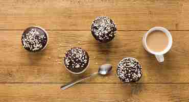 Free photo flat lay of doughnuts on wooden surface with coffee and spoon