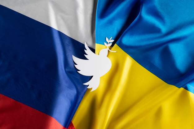 Flat lay dove shape on ukrainian and russian flags