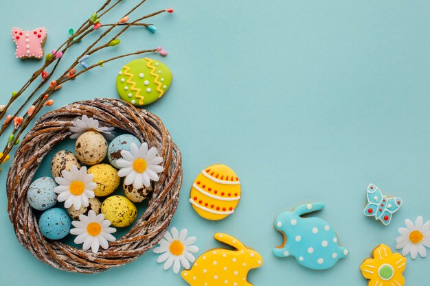 Flat lay of easter eggs in basket with chamomile flowers and bunny shape