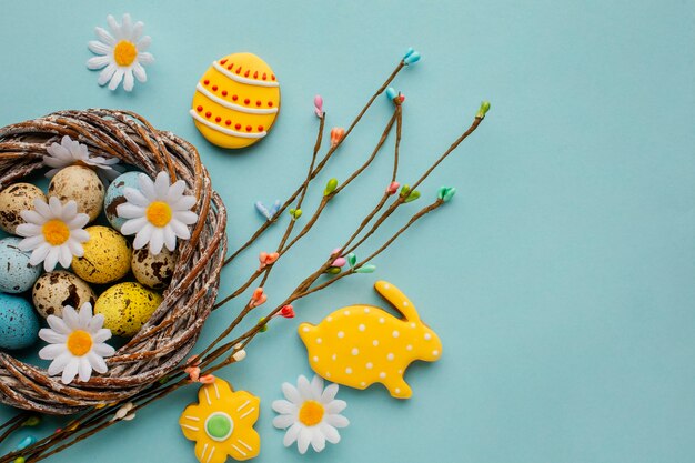 Free photo flat lay of easter eggs in basket with chamomile flowers