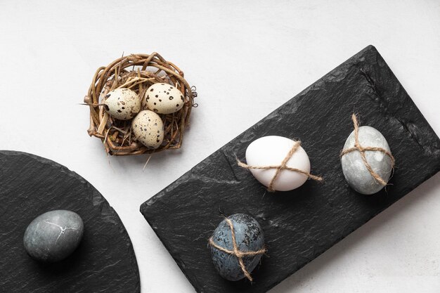 Free photo flat lay of easter eggs in bird nest and slate