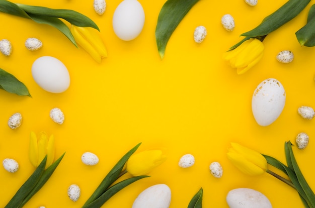 Foto gratuita disposizione piana delle uova di pasqua con la struttura dei tulipani