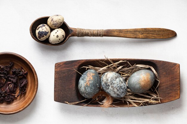 Flat lay of easter eggs on wooden plates and spoon