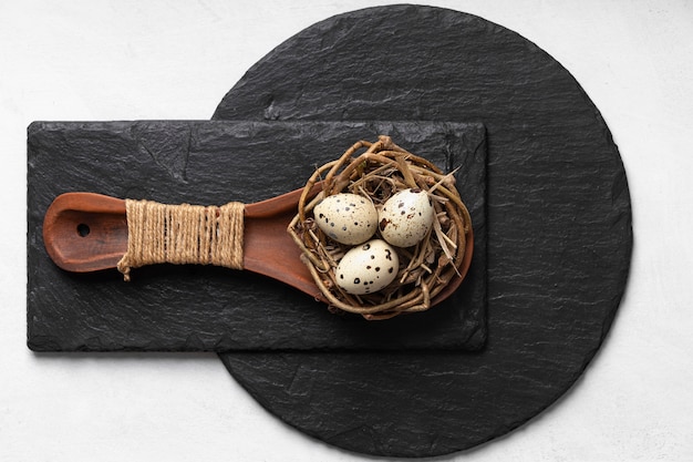 Flat lay of easter eggs in wooden spoon over slate