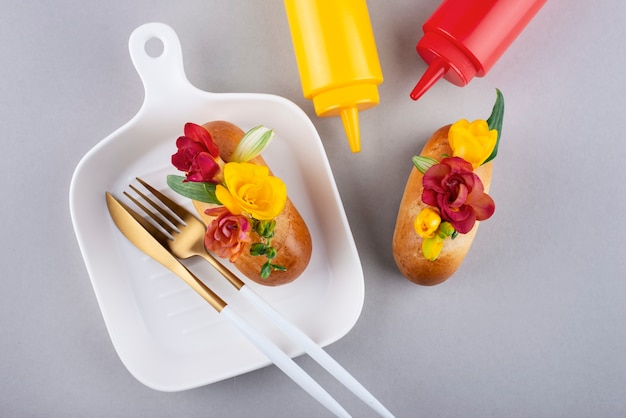 Flat lay eco hot dogs with flowers