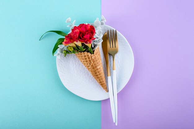 Flat lay eco ice cream cone with flowers