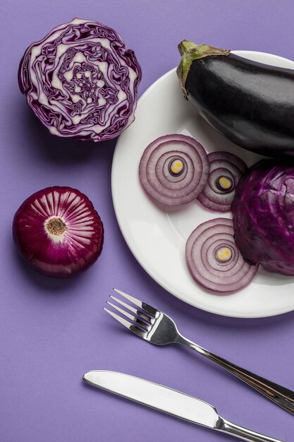 Flat lay of eggplant and onion on plate with cutlery