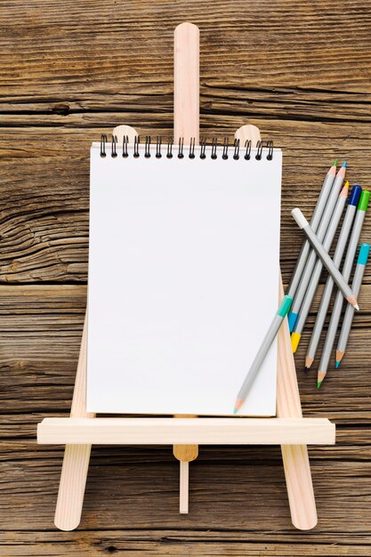 Flat lay empty white notepad and pencils