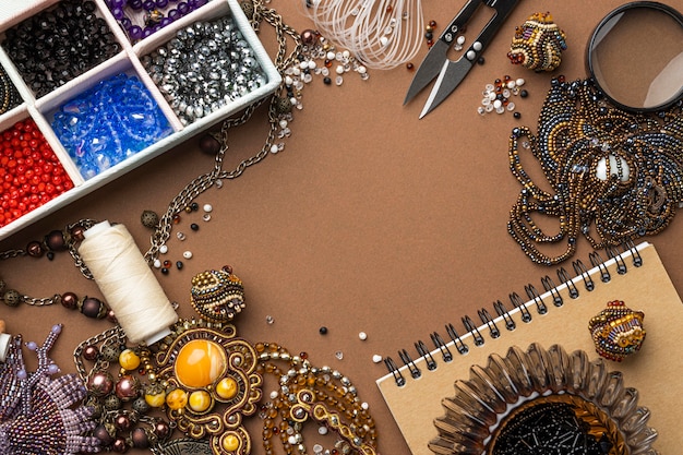 Free photo flat lay of essentials for bead working with scissors and notebook