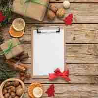 Free photo flat lay festive christmas table arrangement with empty clipboard