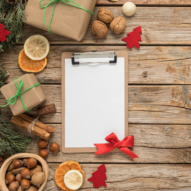 Flat lay festive christmas table arrangement with empty clipboard