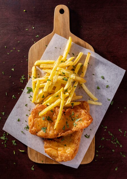 Flat lay of fish and chips on chopping board