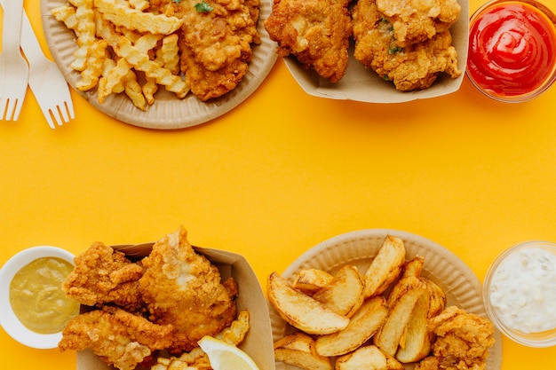 Free photo flat lay of fish and chips with copy space and sauces