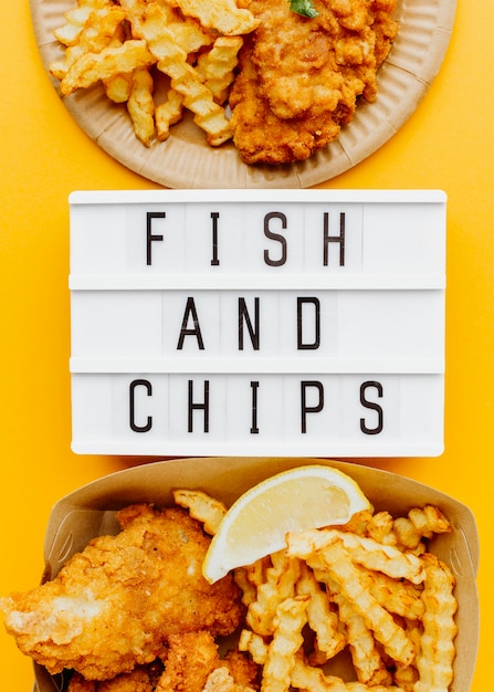 Flat lay of fish and chips with light box and sauce