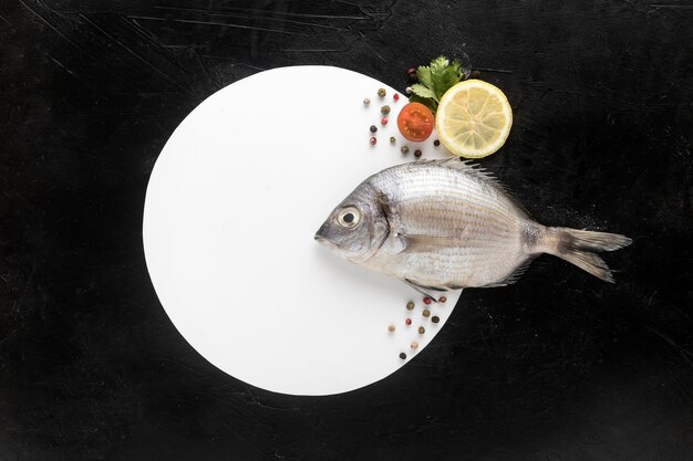 Flat lay of fish with plate and lemon