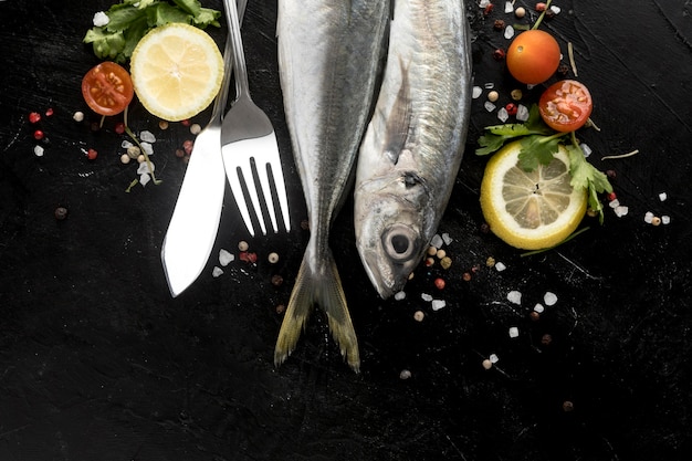 Flat lay of fish with tomatoes and lemon slices