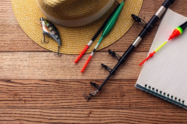 Free photo flat lay of fishing essentials with hat and bait