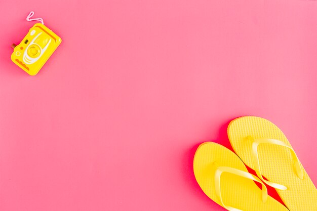 Flat lay of flip flops, photo camera