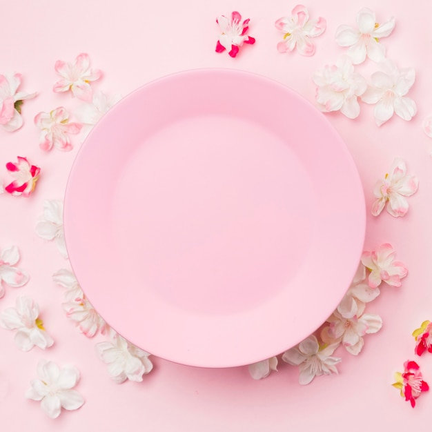 Flat lay flowers and pink plate