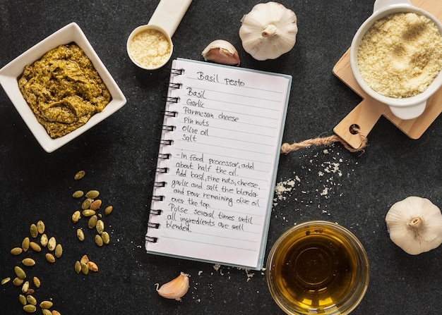 Flat lay of food ingredients with dough and notebook