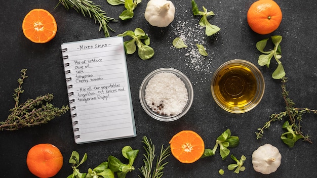 Flat lay of food ingredients with herbs and notebook