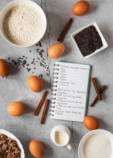 Flat lay of food ingredients with notebook and dessert mix