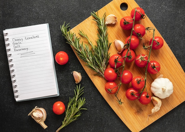 Flat lay of food ingredients with tomatoes and recipe