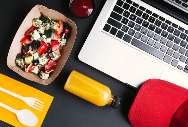 Flat lay food and laptop on black background