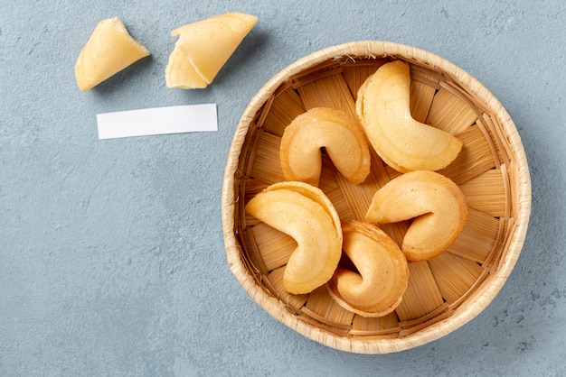 Free photo flat lay fortune cookies in bowl with blank note