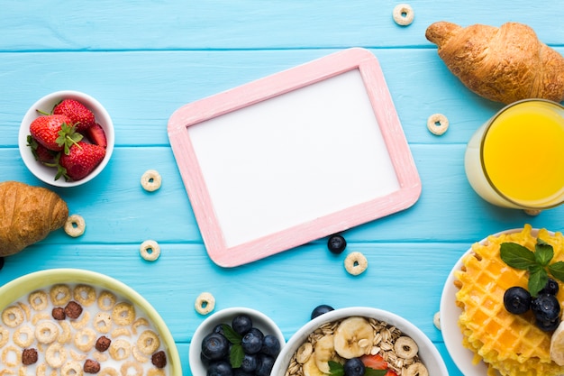 Free photo flat lay frame mockup on breakfast table